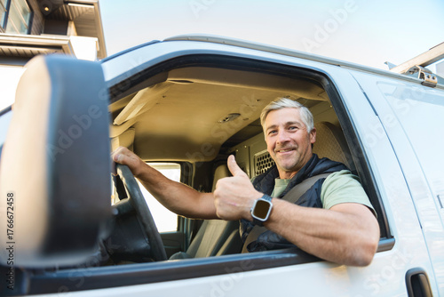 Canvas Print Happy professional truck driver driving his truck