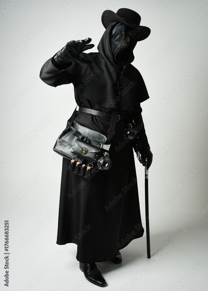 Fototapeta premium Plague Doctor Full length walking Silhouette Portrait of Gothic Halloween Character with Beak Mask, Black Cloak on White Studio Background, Dramatic Dark Costume and Fantasy Horror figure