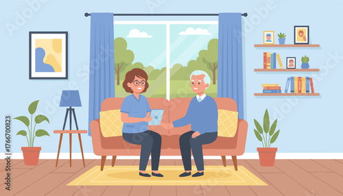 Caring caregiver in blue uniform and glasses shows tablet to smiling elderly man in blue sweater, sitting on sofa in cozy living room with large window overlooking green trees and blue sky
