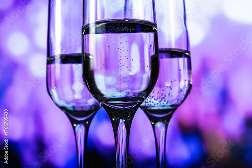 An upscale gathering characterized by illuminated drinkware and energetic social interactions