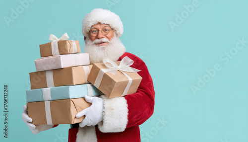 Santa Claus carrying a pile of colorful wrapped gifts with a cheerful expression against a light blue background