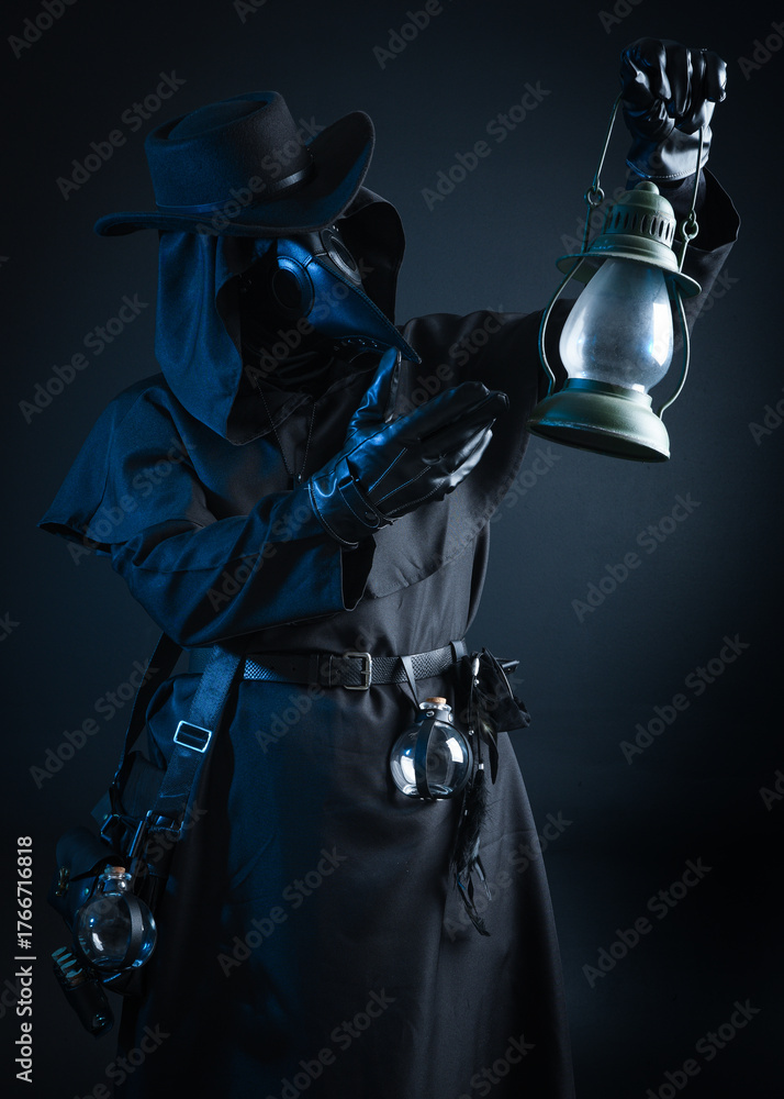 Fototapeta premium Gothic Plague Doctor with Lantern, Halloween Costume Character in Black Cloak and Bird Mask. Dark Studio Portrait with Atmospheric Lighting and Mysterious Fantasy Horror figure