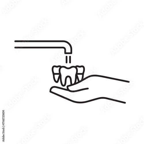 Hand holding teeth under running water from faucet for cleaning
