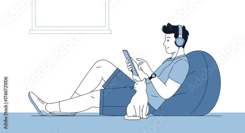 A man relaxing at home indoors with his pet cat and listening to music on tablet