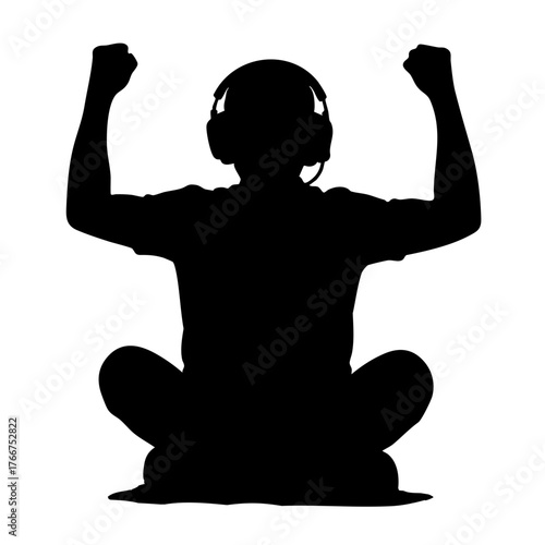 Young boy celebrating victory while gaming at home in silhouette  