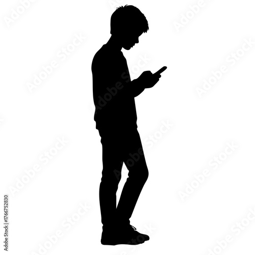 Boy using smartphone while standing in profile silhouette  