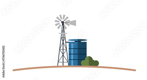Classic windmill and water tank stand on dry landscape, with small green bush adding touch color to the scene