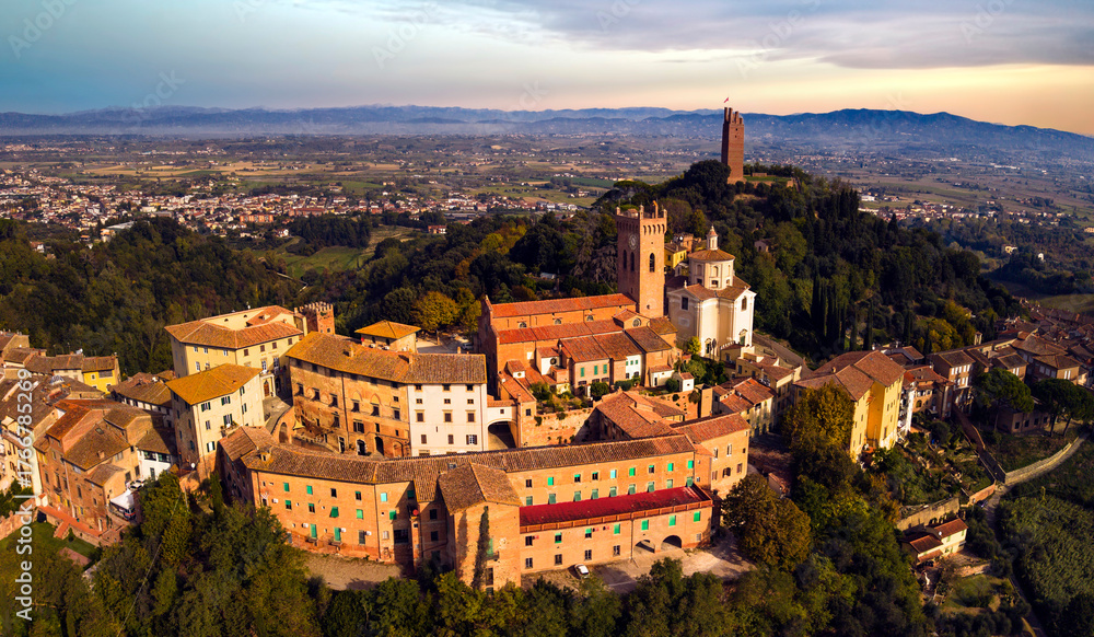 Fototapeta premium Italy tourism. Scenic beautiful medieval villages of Tuscany - San Miniato located on the famous Via Francigena surrounded by vineyards hills. Aerial drone view over sunset