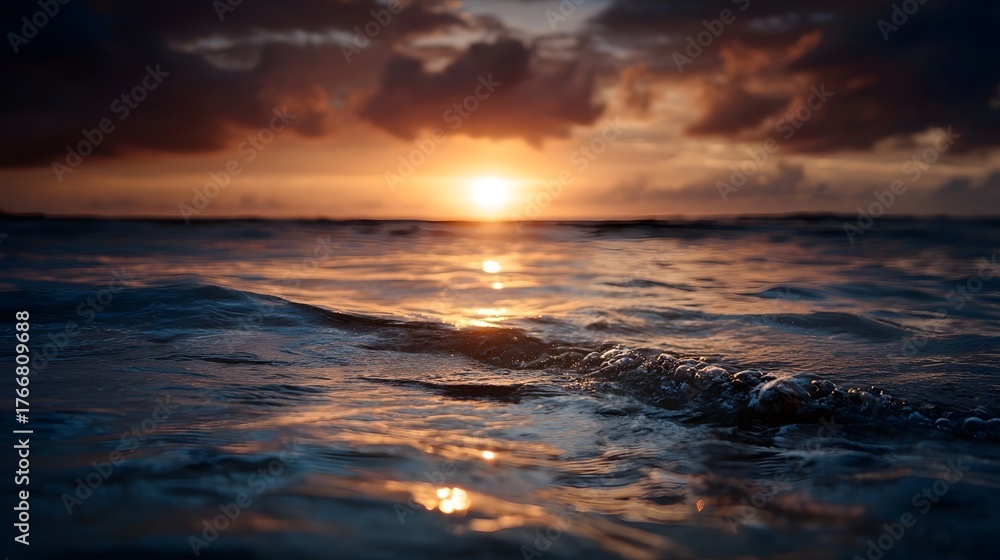 Obraz premium Golden sunset light reflects on the calm ocean waves at dusk