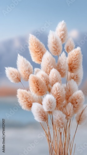 Dreamy Macro Capture of Golden Grass Tufts with Soft Focus Background of Mountains and Water Illuminated by Gentle Sunlight