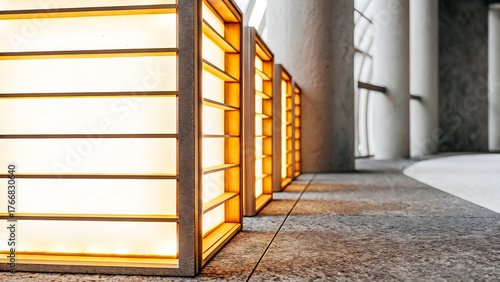 Modern architectural lighting design featuring illuminated rectangular panels in a contemporary building hallway with textured flooring