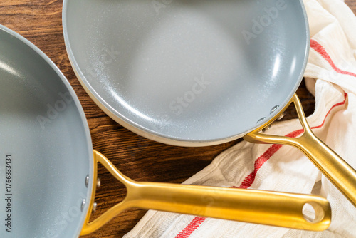 Two ceramic frying pans with golden handles