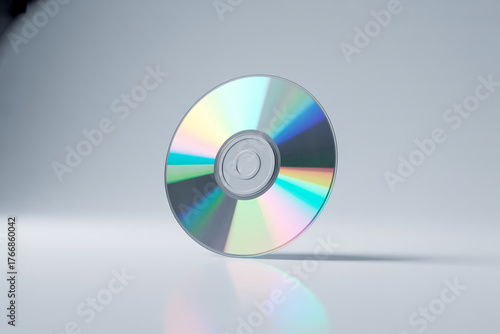 Compact disc standing on a reflective surface with a gradient background