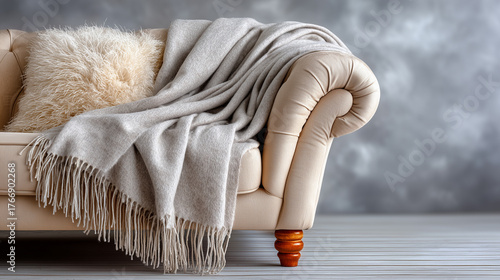 Cream-colored sofa corner with cashmere throw blanket in minimalist bright setting