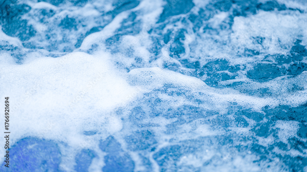 Obraz premium Close-up of foamy water with bubbles and a blue hue, creating a refreshing scene