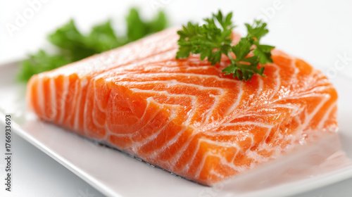 Frisches Lachsfilet mit Petersilie auf weißem Teller

