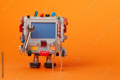 A toy mechanical robot holds repair tools. A robot mechanic handyman repairman character with a pliers, hand wrench. Orange background. Copy space for text