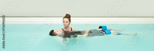 Cuadro en lienzo Aquatic therapy session with female therapist assisting young male patient in a pool