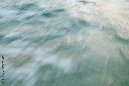 Abstract motion blur of water waves in soft pastel hues