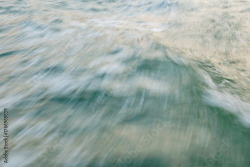 Abstract motion blur of ocean waves with blue and green hues
