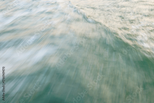 Abstract motion blur of ocean waves in soft pastel hues