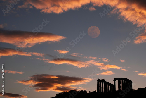 Ancient ruins with moon at dusk. A Greek temple of Poseidon during sunset in the summer.