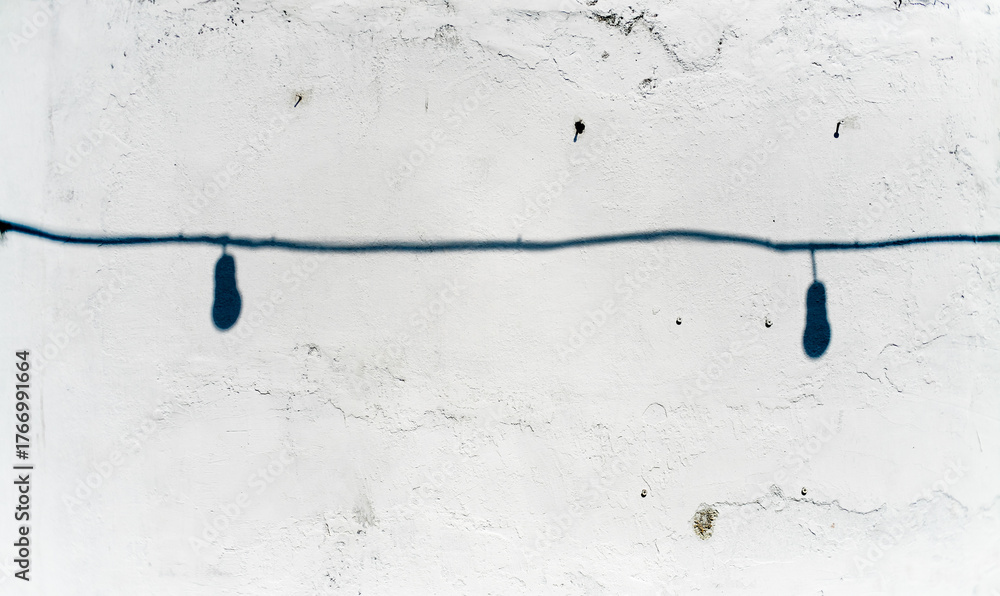 Fototapeta premium shadow of lighbulb with cable on white grunge wall