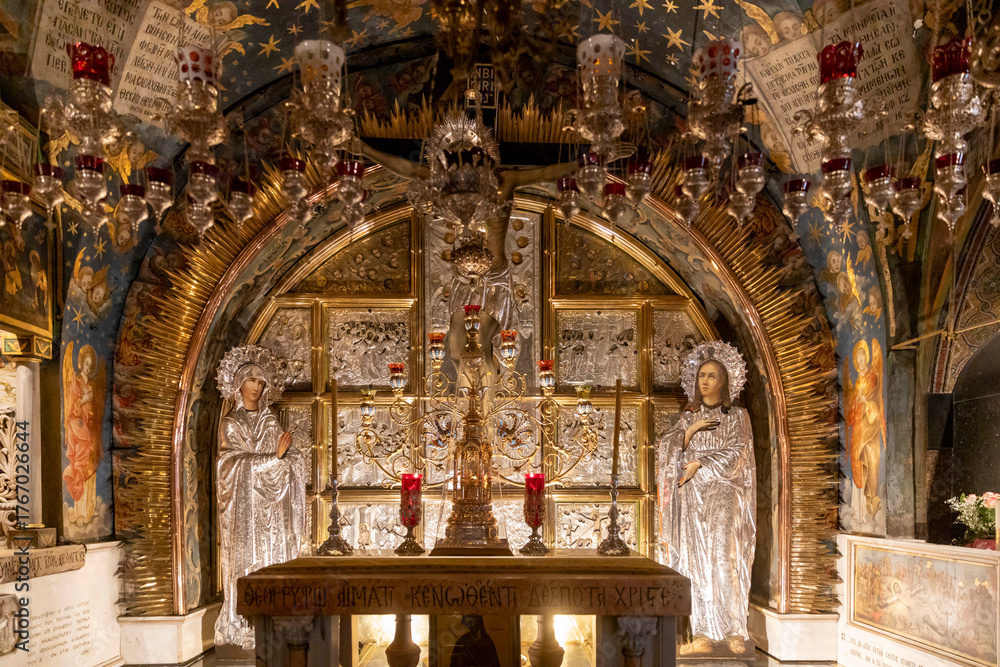 Obraz premium Jerusalem, Israel, 23 October 2025, The heavily ornate and gilded altar of the chapel of adam in the church of the holy sepulchre is illuminated by candlelight, beneath a richly painted ceiling.