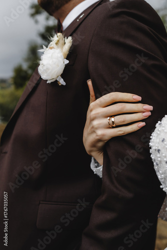 Close-up of the bride holding the groom's arm