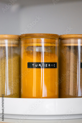 Neatly organized labeled food pantry in a home kitchen with spices grains flour rice sugar nuts