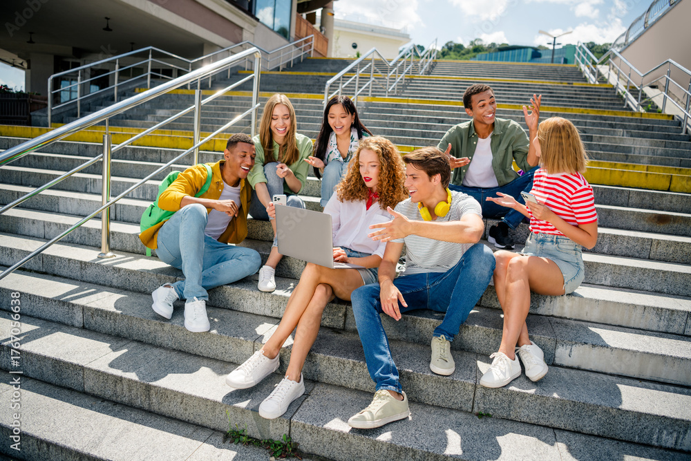 Fototapeta premium Buddies sitting outdoors on steps bonding and enjoying teamwork during a bright summer day