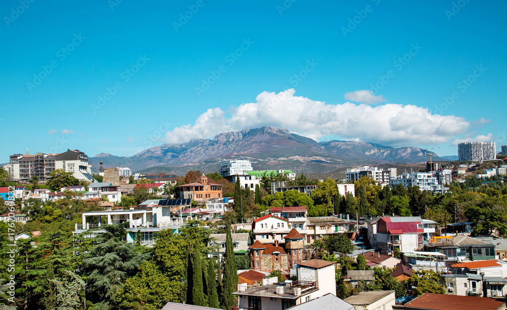 Obraz premium View of the village of Alushta with mountain hills on a clear sunny day. Landscape, sights of Russia, sea, mountains.