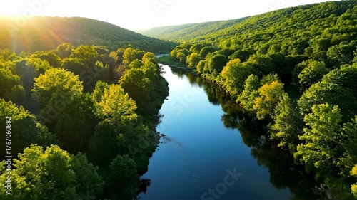 Aerial view of a winding river flowing through a lush green valley at sunrise river, landscape, exploration