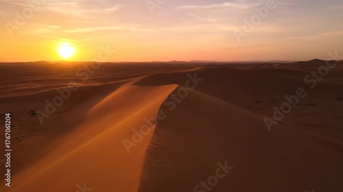 Cinematic slow drone shot over a vast, remote desert landscape at golden hour, shallow depth of field solitude, landscape, destination