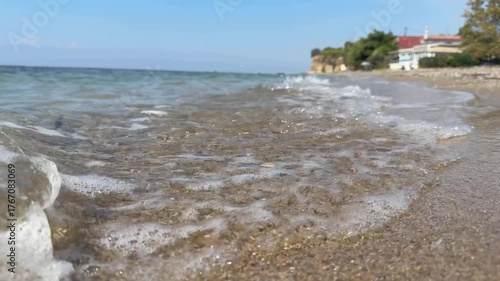 Slow motion as sea waves crash against the sandy shore.  Seaside vacation. The coast of the Aegean Sea in Greece, Halkidiki. Relaxing.