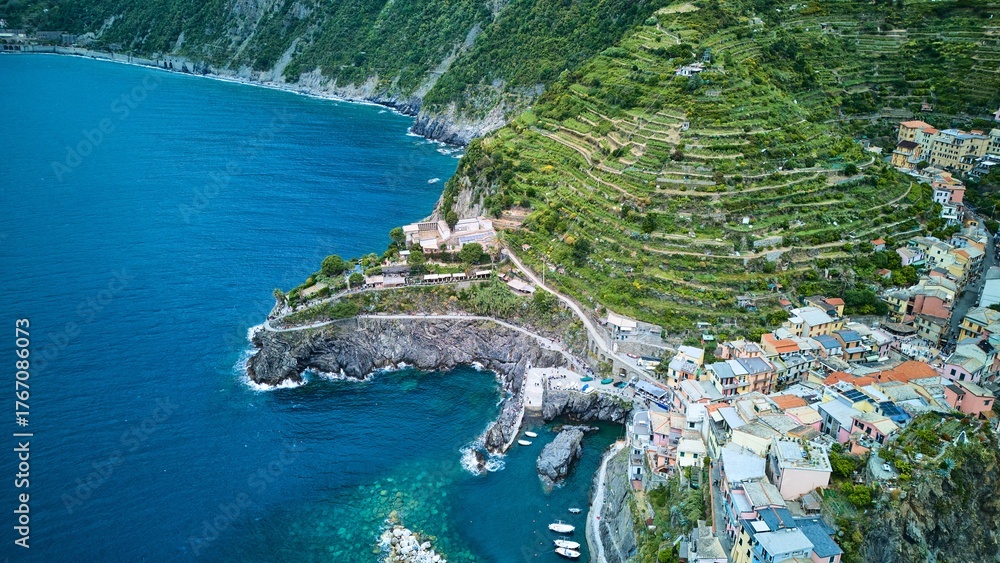 Naklejka premium Drone oblique of Manarola’s tiny harbor, terraced vineyards and open Ligurian Sea framed by steep headland, Cinque Terre, Italy