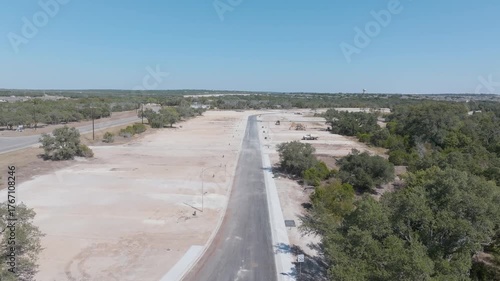 Drone flyover a cleared building site for a new development of over-55 homes near Georgetown Texas with some equipment visible