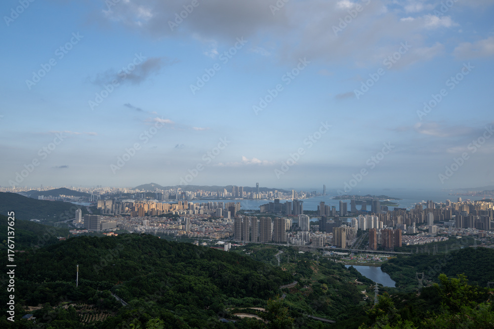 Fototapeta premium A Breathtaking Panoramic View of a Modern Cityscape Blending with Lush Mountainous Terrain