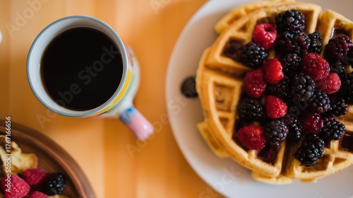 highangle. A delicious breakfast spread featuring waffles, berries, and coffee from a high-angle view. menu design, packaging mockups, designed for food delivery and cloud-kitchen brand materials.