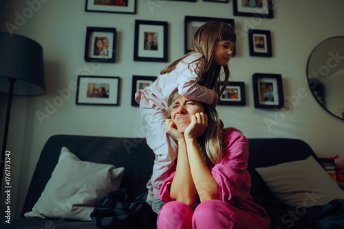 Naughty Child Climbing on her Own Exasperated Mom. Hyperactive girl driving her babysitter crazy crossing the line 