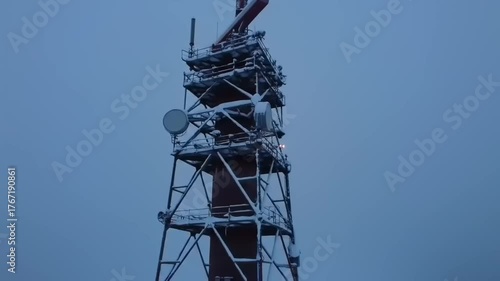 Tower structure against cloudy sky with antennas and communication equipment