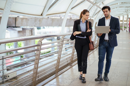 Business people walking and talking together in modern city.