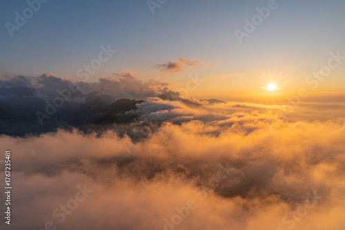 Golden sunset above the Hohen Kasten mountain in Appenzell, Switzerland. Stunning view over the Alps and the Rhine Valley with glowing clouds and peaceful alpine atmosphere.
