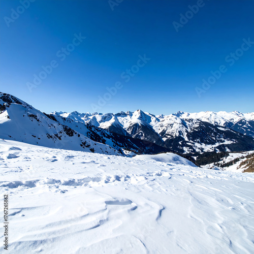 Snow covered mountains under a clear blue sky winter landscape scene