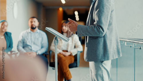 Podium, speaker and hands with audience at conference, workshop or symposium for skill development. Corporate talk, presenter person with discussion or keynote speech at upskill seminar in business