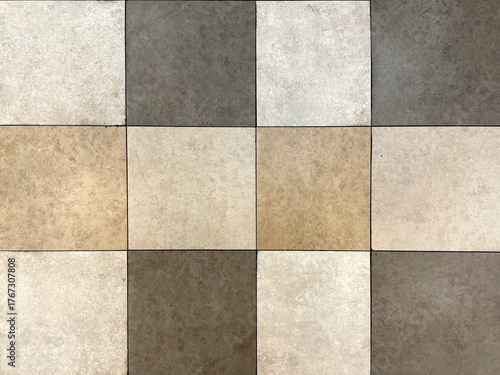 Close up of square stone tiles in dark brown, natural brown, and white color. Suitable for outdoor pavement paving tiles. Seamless background texture.