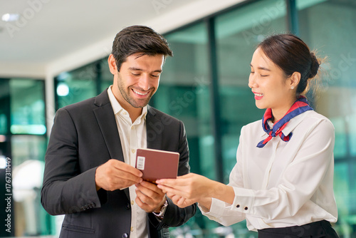 Air ground staff help a businessman passenger check in at the counter of airport.