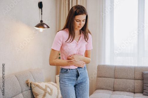 Young Woman Suffering From Abdominal Pain at Home