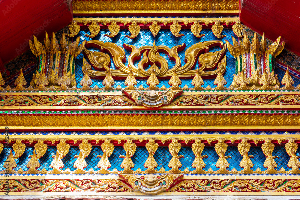 Fototapeta premium Close-up reveals ornate details of a temple's architectural elements, Golden thai art pattern in temple roof of Thailand