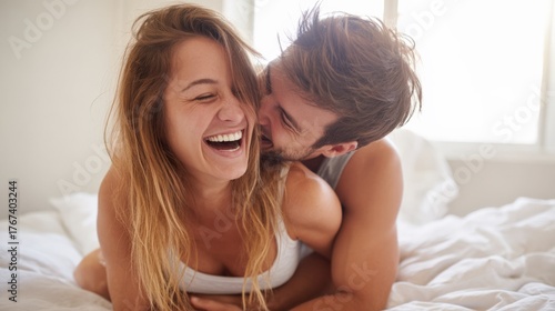 Laughing couple cuddling in bed, embracing intimacy and connection, enjoying joyful moments together